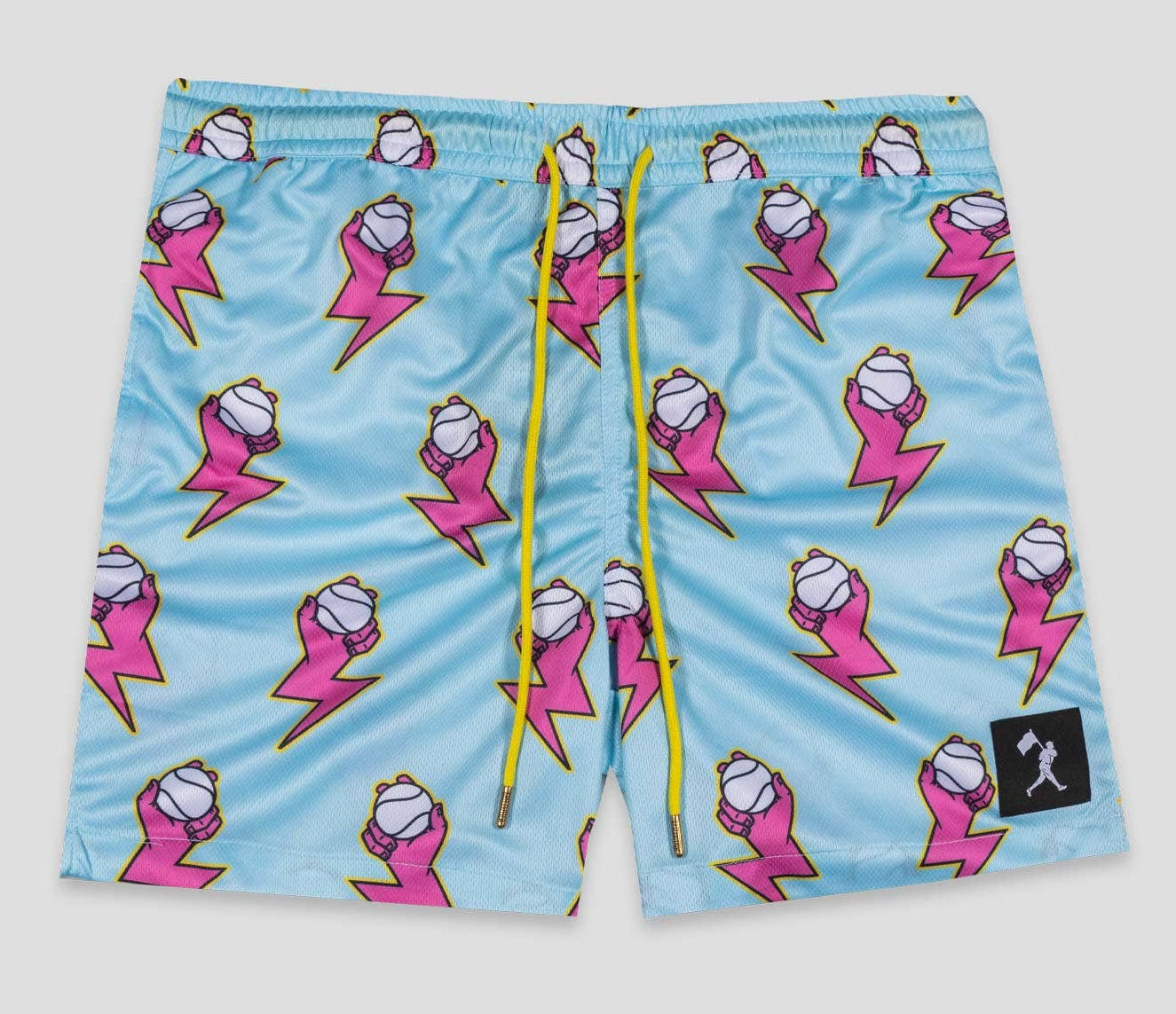 Blue swim shorts with pink cartoon character pattern on a gray background
