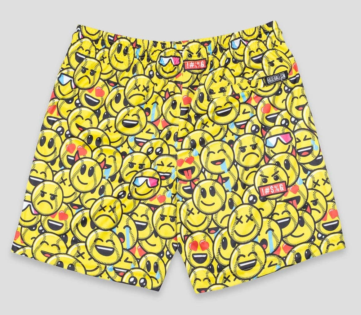 Yellow swim shorts with emoji pattern on a gray background